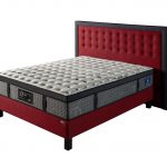 Photo présentant un lit composé d'un matelas à ressort de haute qualité blanc et gris de hauteur : 32, ainsi qu'une tête de lit en tissu gris foncé et rouge capitonné.