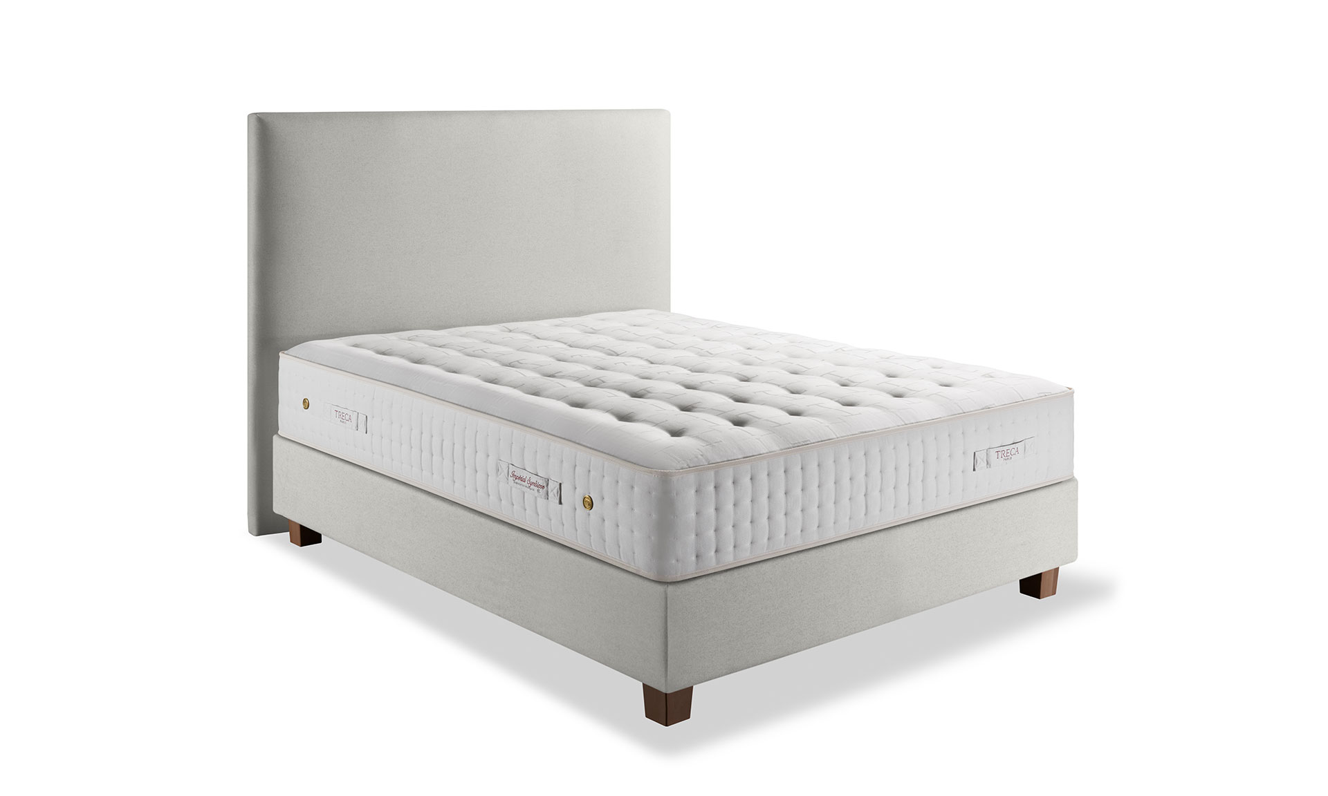 Photo présentant un lit composé d'un matelas en latex blanc de hauteur : 32, ainsi qu'une tête de lit en tissu blanc crème.